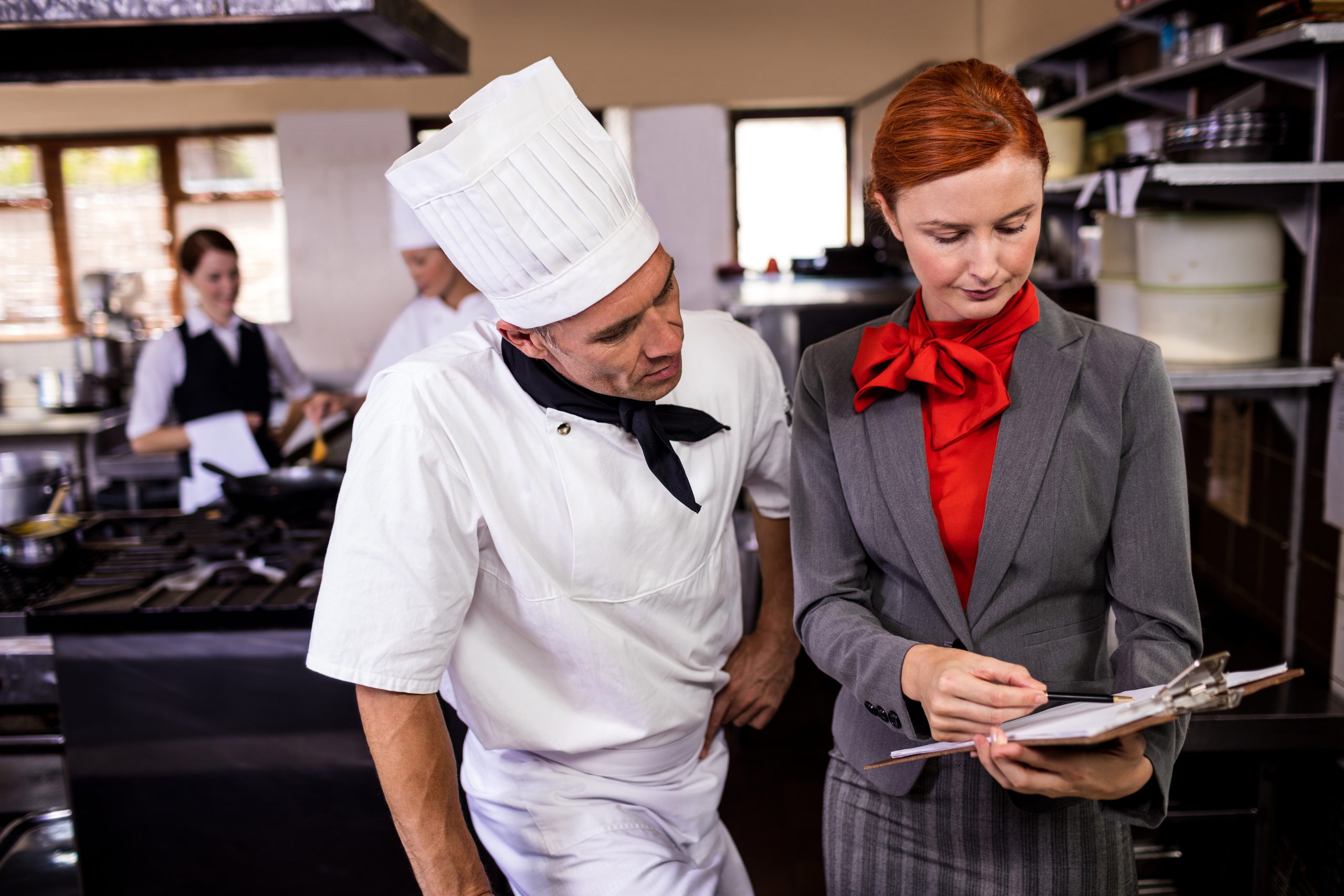 Restaurant manager and chef reviewing operational processes together
